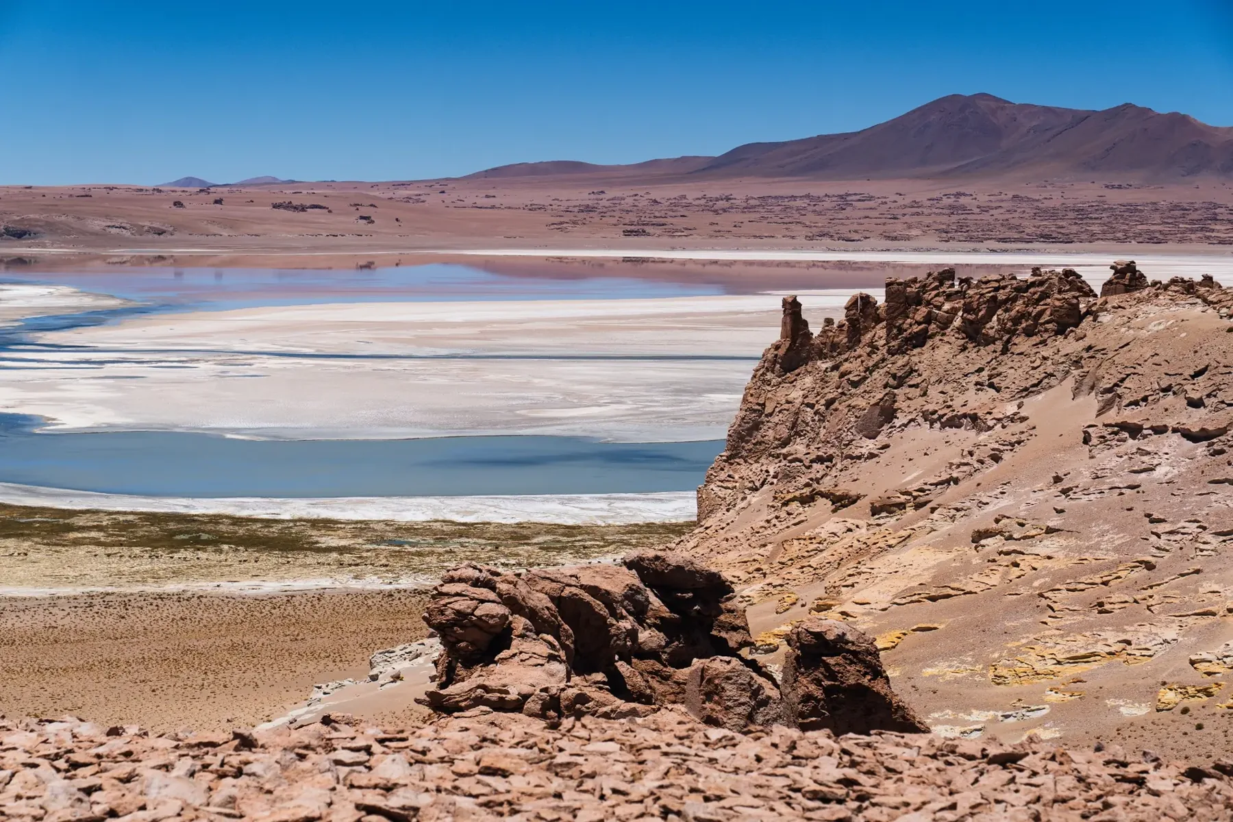 Laguna del altiplano entre salares, montañas y luz del desierto de Atacama.